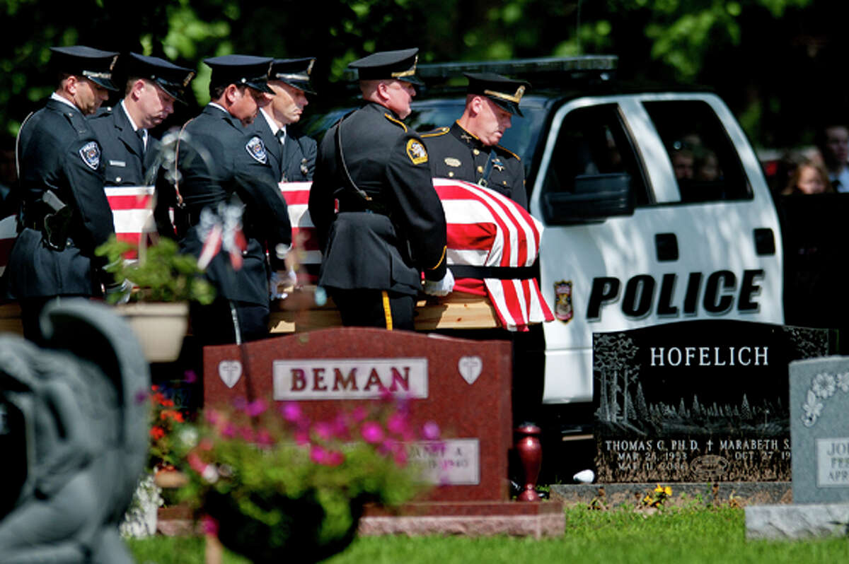 Police carry the casket of Rapid City Police Officer J. Ryan McCandless during the funeral for McCandless Thursday, Aug. 11, 2011, at the Midland Cemetery in Midland Mich. In the background is McCandless' patrol vehicle. McCandless was killed in the line of duty last week in South Dakota. McCandless, a 2001 H.H. Dow High graduate, is the son of retired Midland County Undersheriff James McCandless.