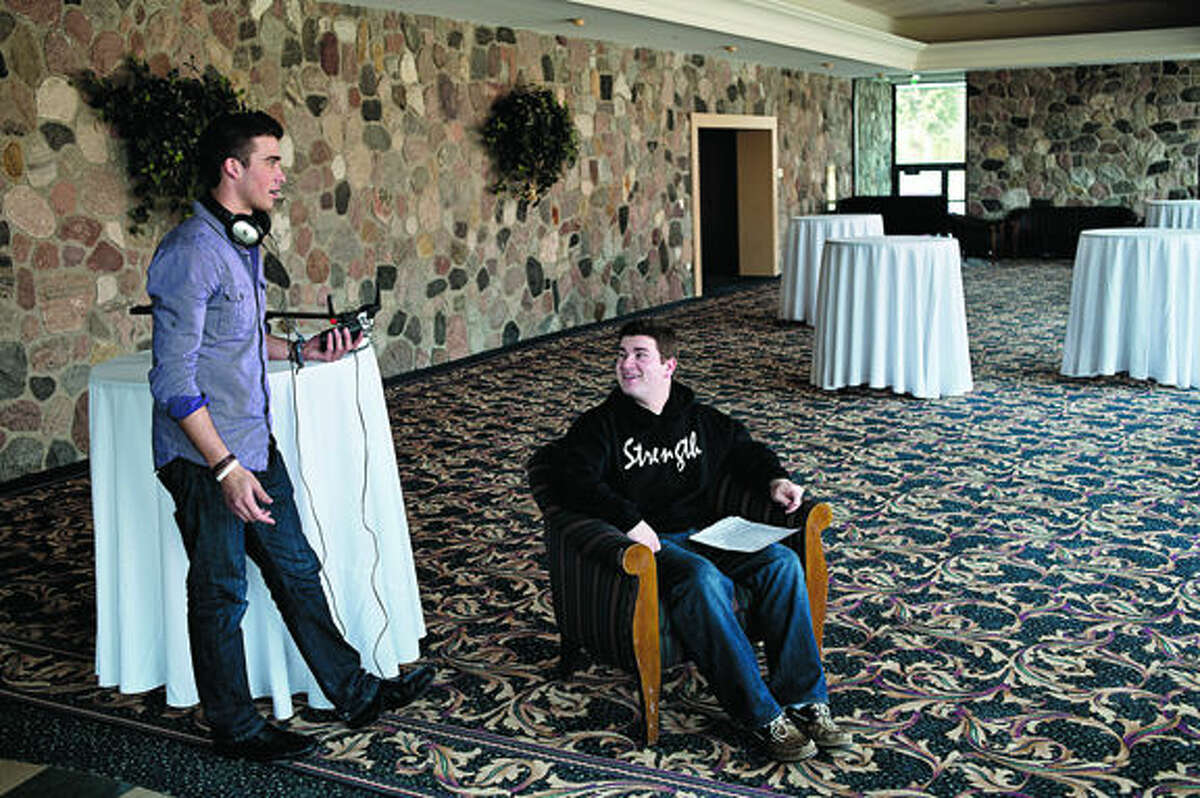 Michael Rubenstein, 20, center, a Northwood junior, looks up at Sterling Adgate, 21, also a Northwood junior, while filming a promotional video for an upcoming fundraiser event Wednesday afternoon in the lobby of the Great Hall Banquet and Convention Center.
