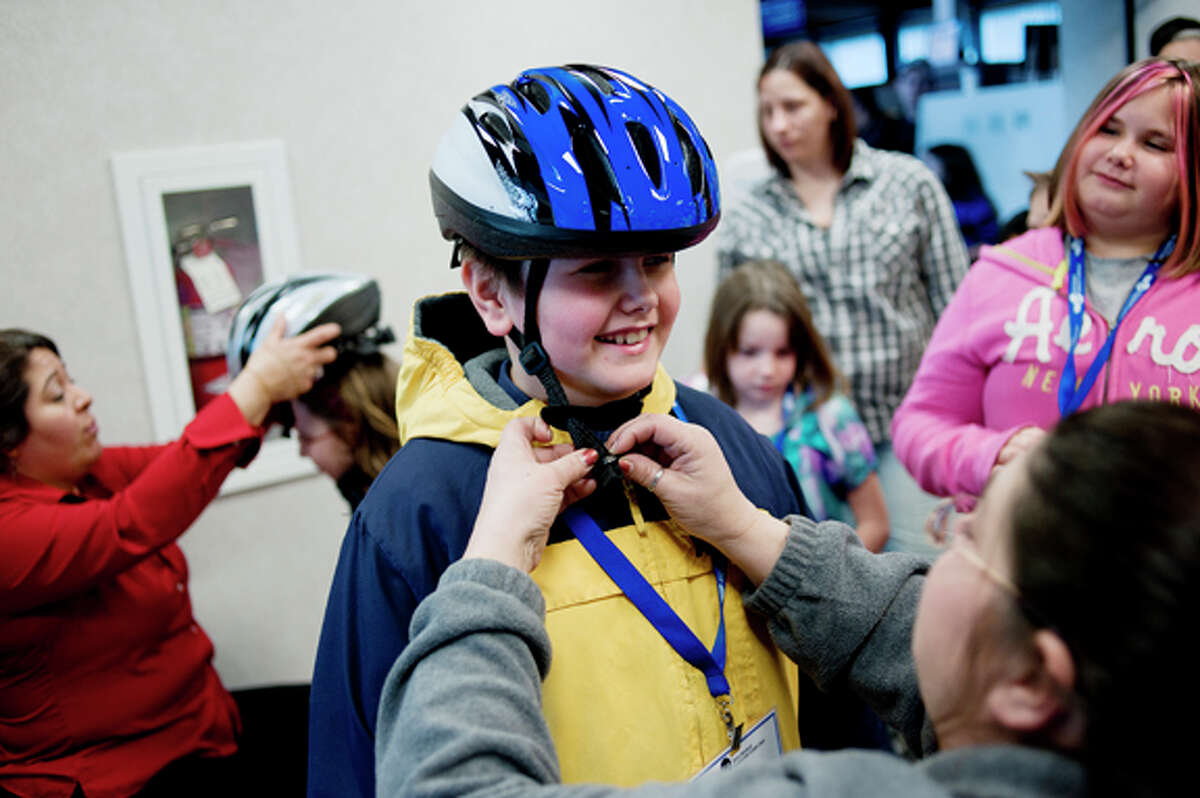 Brayton Ambes, 9, smiles as he’s fitted for a helmet by St. Mary’s Field Neurosciences Institute employee Tami Bersano.