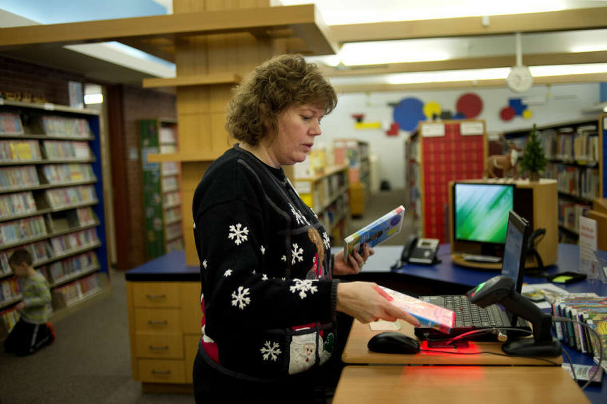 NICK KING | nking@mdn.netYouth Services LIbrarian Katrina Dumont works on adding items to the new self-checkout system database which is being installed as part of the renovations to the Grace A. Dow Memorial Library. The new system will allow patrons to self-checkout items from three stations at the library. The system doesn't eliminate any jobs and there will still be staff on hand to checkout items personally.