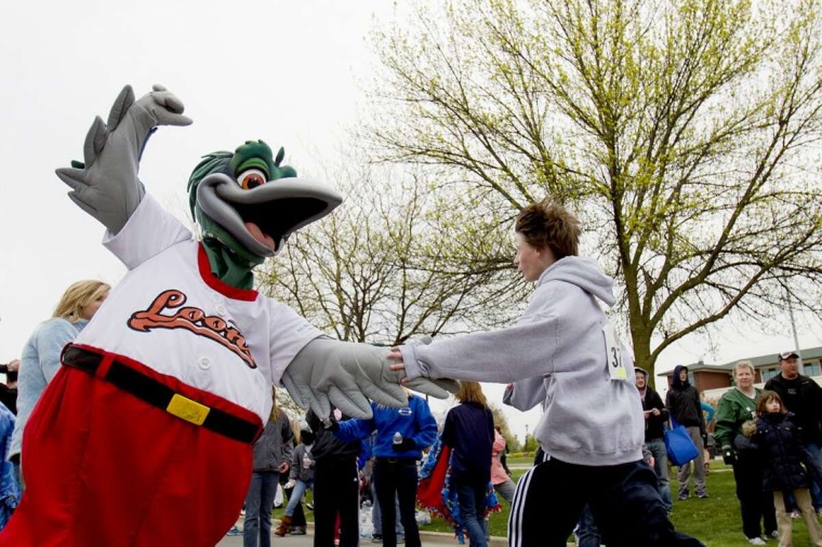 Mike Mulholland for the Daily News Great Lakes Loons mascot Lou E. Loon slaps the hand of Midland's Brennan Baldwin, 13, Saturday morning after Baldwin finished the Great Lakes Loons Race for the Pennant with a time of 27:02.