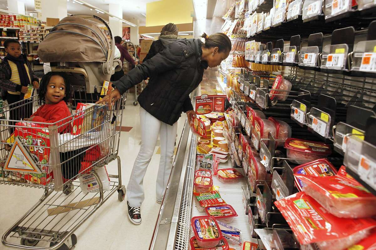 Jancy Beatriz, 3, left, looks at his mother Raquel Beatriz shop by a decimated cold cuts aisle at a Giant grocery store in Washington, on Friday, Feb. 5, 2010, hours before a massive snow storm was expected to hit the area. (AP Photo/Jacquelyn Martin)