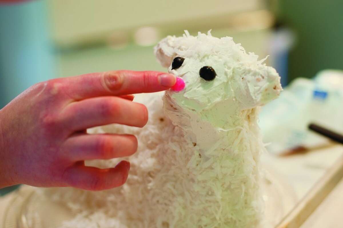 NEIL BLAKE | nblake@mdn.net Ruth Clark of Midland puts on a pink jellybean nose on a lamb cake. The jellybeans and coconut complete the look of the cake.
