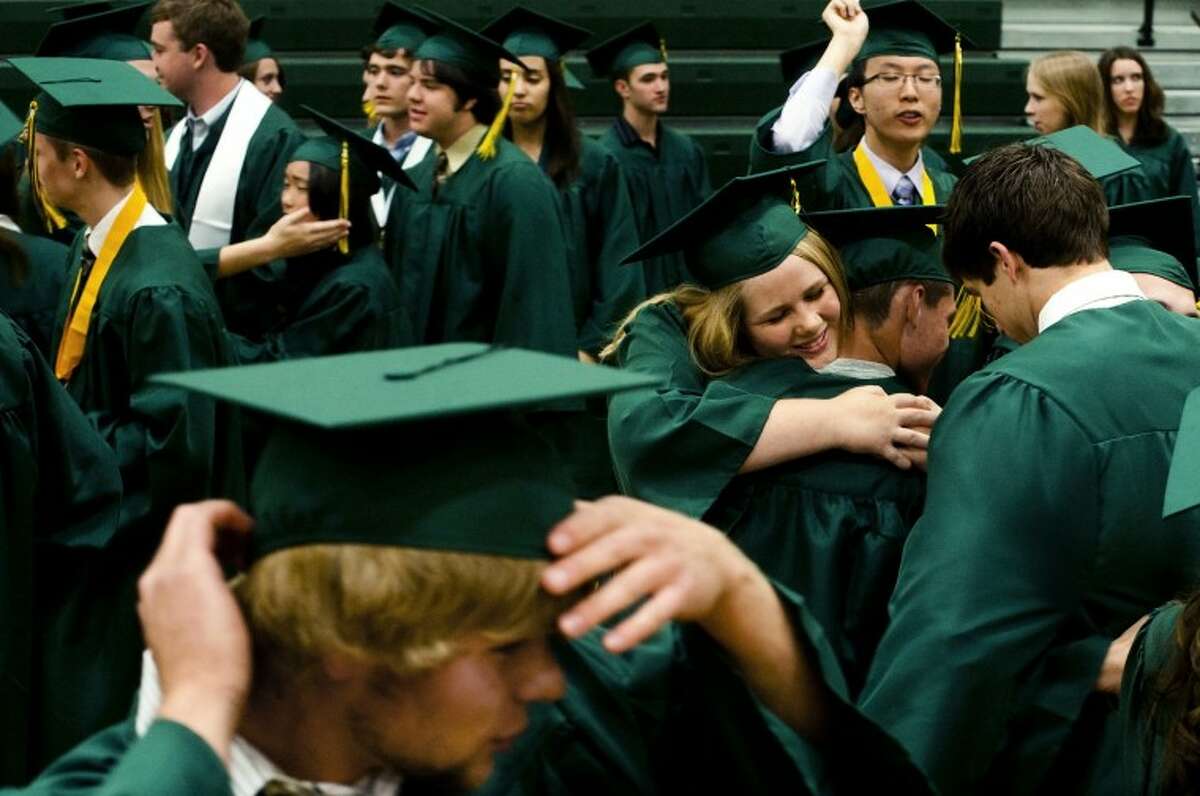 JAKE MAY | for the Daily NewsAfter running across the room in celebration, Dow High School graduate Hannah Martin, 18, center left, smiles as she embraces classmate and friend Hayden Gosen, 17, while other members of the 2012 Dow High School graduating class file into lines, fix their caps and prepare to receive their diplomas on Friday night at Dow High School. "It's truly surreal that graduation is already here," Martin said. "I'm dumbfounded that the time is actually here and we're all moving on."