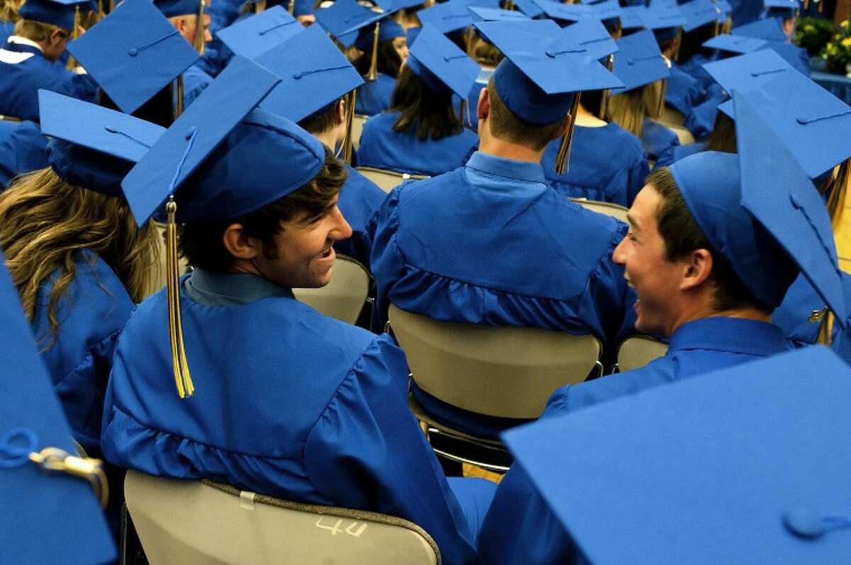 JAKE MAY | for the Daily NewsMidland High School graduates Travis Walker, 18, left, laughs with his friend Garrett Wallen, 17, as the two try to keep a light mood while listening to the 360 names being called off during Friday night's commencement ceremony at Midland High School.