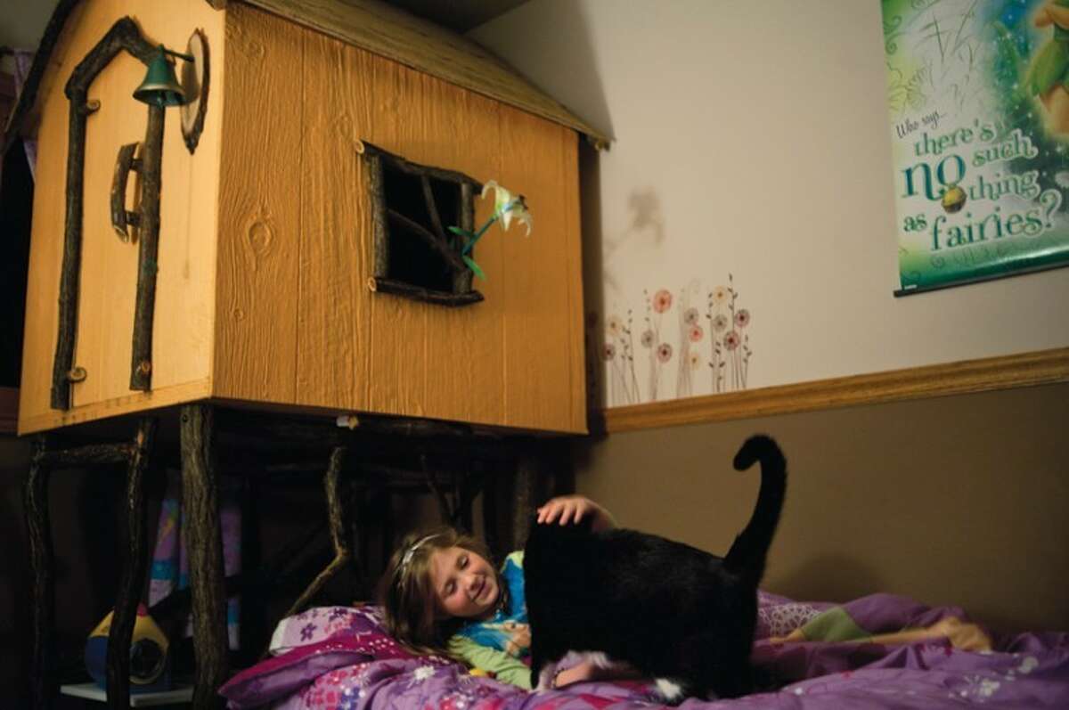 LIBBY MARCH | for the Daily News Gretchen Shope, 5, plays with 7-year-old Mona before going to sleep at the Shope home in Midland on Thursday, October 13, 2011.