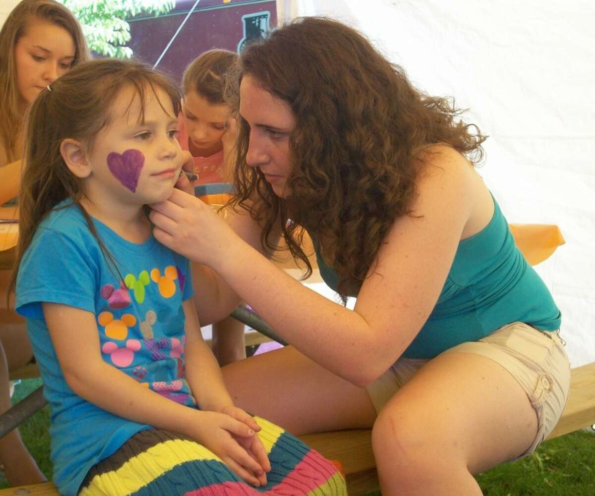 Patti Brandt | for the Daily NewsAva Massey, 5, of Midland, gets her face painted by volunteer Maggie Thompson, a student at Dow High School, at the Be a Tourist in Your Town event.