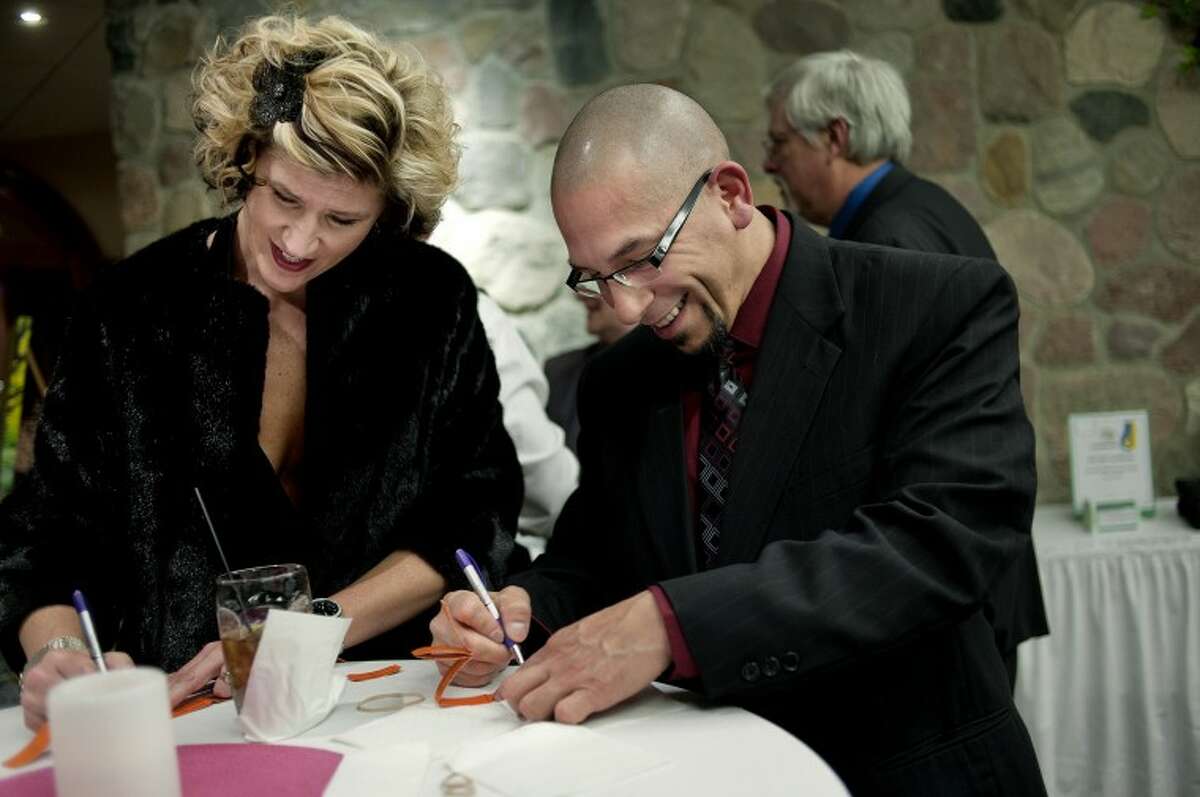 NICK KING | nking@mdn.netCancer Services board member Courtney Szelesi, left, and Everett Menchaca fill out raffle tickets during the Cancer Services' "Spring to the Beat" Dinner Dance benefit Saturday at the Valley Plaza's Great Hall. The two work with cancer patients at MidMichigan Medical Center-Midland. The event featured dinner, live music, raffles and a silent auction.