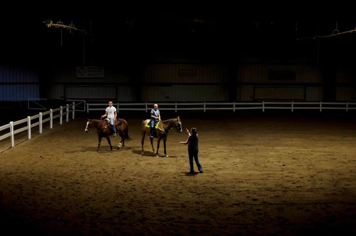 Bullock Creek freshman Brandt Gaffke, left, and sophomore Kim Chapin, center, listen to speed coach Cami Comper atop their horses, Sadie and Sundae respectively, during practice at the Midland County Fairgrounds on Oct. 11.  The practice was their last before the Michigan Interscholastic Horsemanship Association state championship,  which was held at the Midland County Fairgrounds, very familiar terrain to the team who often practice and compete on the same soil. This is the fifth year straight that the team has competed at the state championship.Bullock Creek freshman Brandt Gaffke, left, and sophomore Kim Chapin, center, listen to speed coach Cami Comper atop their horses, Sadie and Sundae respectively, during practice at the Midland County Fairgrounds on Oct. 11.  The practice was their last before the Michigan Interscholastic Horsemanship Association state championship,  which was held at the Midland County Fairgrounds, very familiar terrain to the team who often practice and compete on the same soil. This is the fifth year straight that the team has competed at the state championship. For more photos from the team’s season see www.mdnvisuals.com.