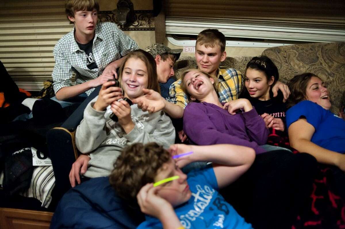 Members of the Bullock Creek equestrian team and their friends laugh and tease each other while watching a movie on the last night of the Michigan Interscholastic Horsemanship Association state championship at the Midland County Fairgrounds on Oct. 14. Most of the team stays near the horses at the fairgrounds in campers making for late nights and early mornings.