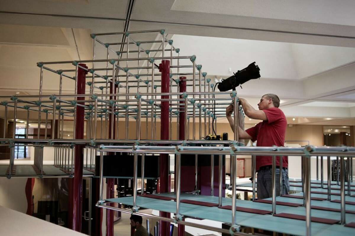 SEAN PROCTOR | photo@mdn.netJustin Herline, of Hemlock, an employee with Thomas Trombley Electric, installs a light fixture on an exhibit in the Hall of Ideas at the Midland Center for the Arts. The permanent exhibition is currently being renovated.