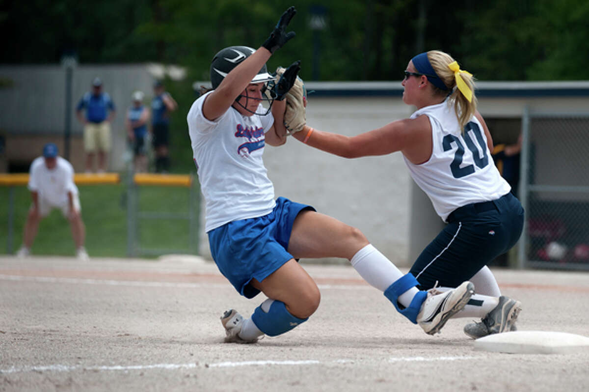 Ariel Cammin of the Midland Lady Explorers tries to slide into third base before Natalie Lampman of Ann Arbor Gold catches the ball in the fourth inning of Lady Explorers game against Gold on Saturday. This is the only tournament the Lady Explorers will have for the summer.