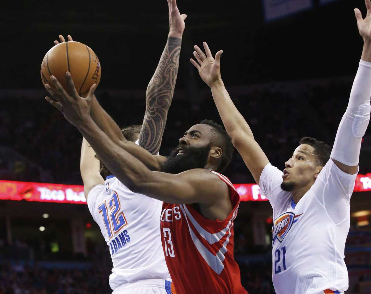 Houston Rockets guard James Harden (13) shoots between Oklahoma City Thunder center Steven Adams (12) and guard Andre Roberson (21) during the first quarter of an NBA basketball game in Oklahoma City, Tuesday, March 22, 2016.