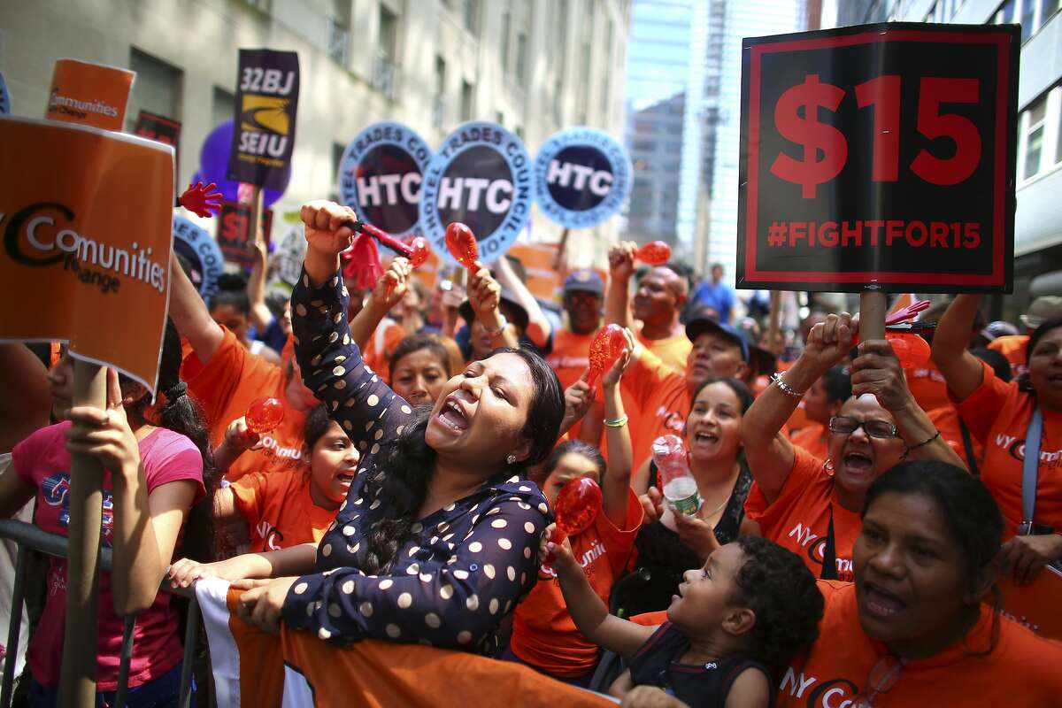 Fast food workers and supporters gather to watch for the live-streamed wage board decision in New York, July 22, 2015. This week, workers in Los Angeles County and Washington, employees of fast-food chains in New York state and the staff of the University of California all heard that they may soon be earning a minimum of $15 an hour. (Chang W. Lee/The New York Times)