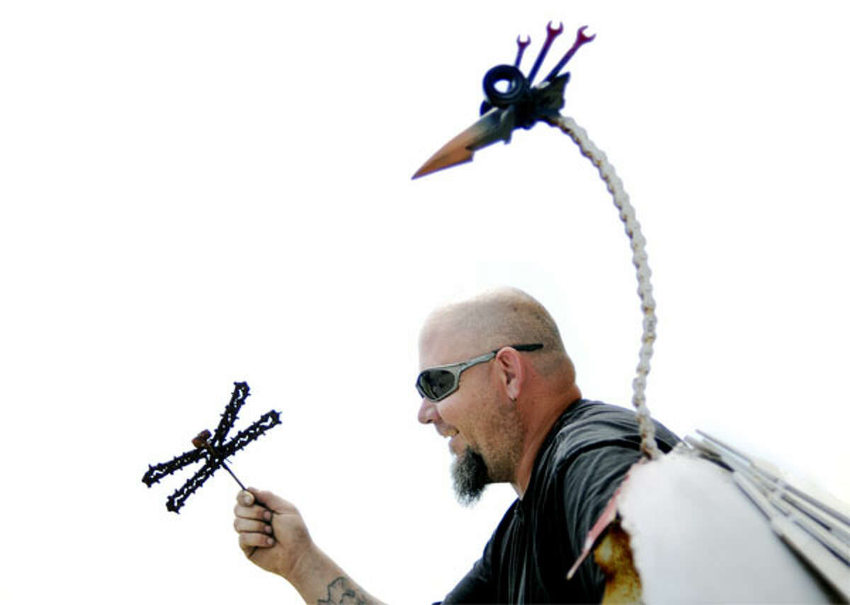 Metal Art Gladwin mechanic hangs welded sculptures outside MidState Rental