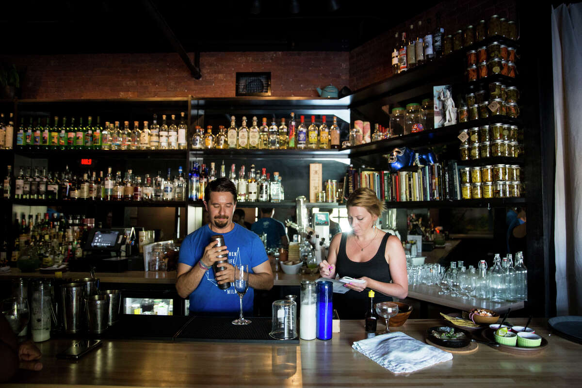 Jesse Torres and Amber Gibson work behind the bar at Mezcalaria Mixtli. The bar announced over the weekend that it's closing.