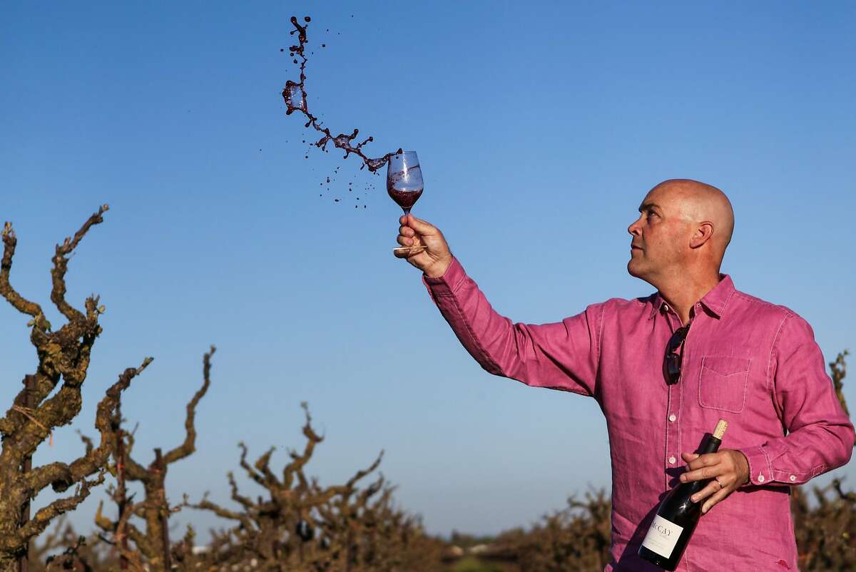 Winemaker Michael McCay tosses wine out of glass while he swirls it, at TruLux vineyard, in Lodi, California, on Thursday, March 17, 2016.