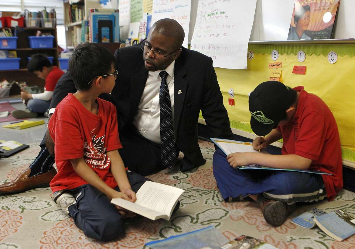 Oakland school district's Superintendent Antwan Wilson, center, speaks with fourth grader Derek Chang, left, during a tour of the Lincoln Elementary school along with Mayor Libby Schaaf in Oakland, Calif., on Thursday, March 24, 2016. The tour highlights the school's success in closing the achievement gap, as can be seen in the Education Equality Index.
