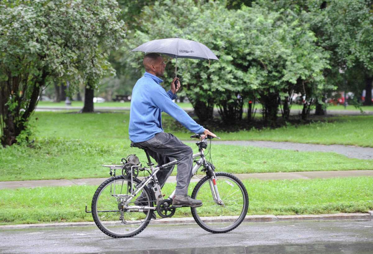 This intrepid cyclist does a balancing act of holding and umbrella and riding his bicycle along Madison Avenue near Washington Park on Sept. 6, 2011, in Albany, N.Y. (Skip Dickstein/ Times Union)