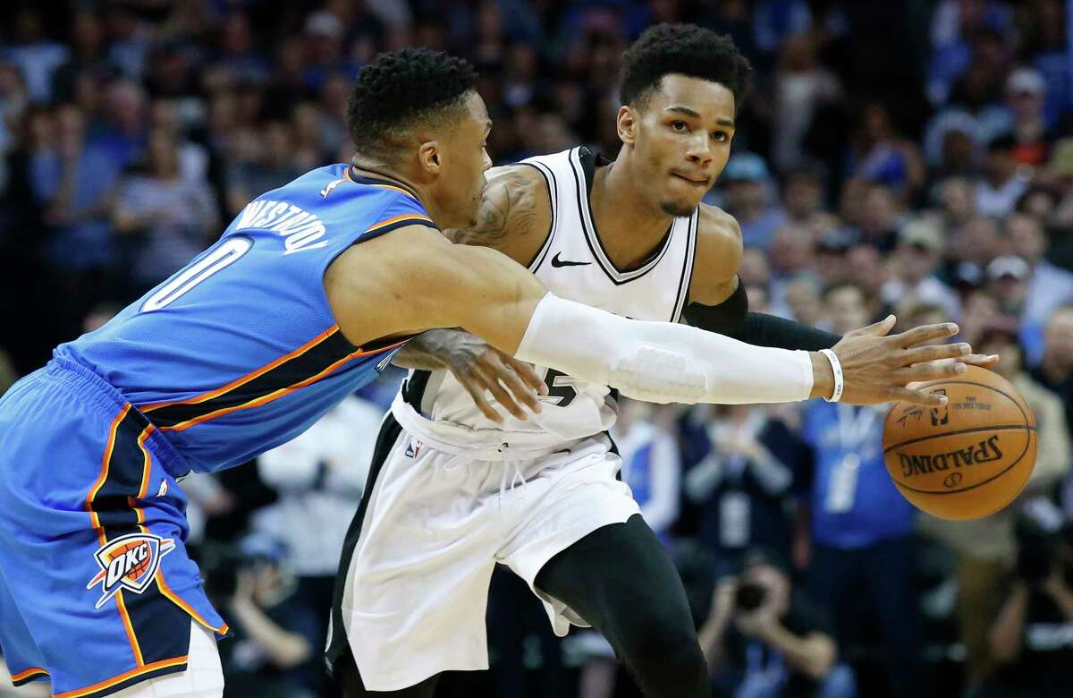 Oklahoma City Thunder guard Russell Westbrook (0) reaches for the ball as San Antonio Spurs guard Dejounte Murray, right, dribbles in the first half of an NBA basketball game in Oklahoma City, Saturday, March 10, 2018. (AP Photo/Sue Ogrocki)