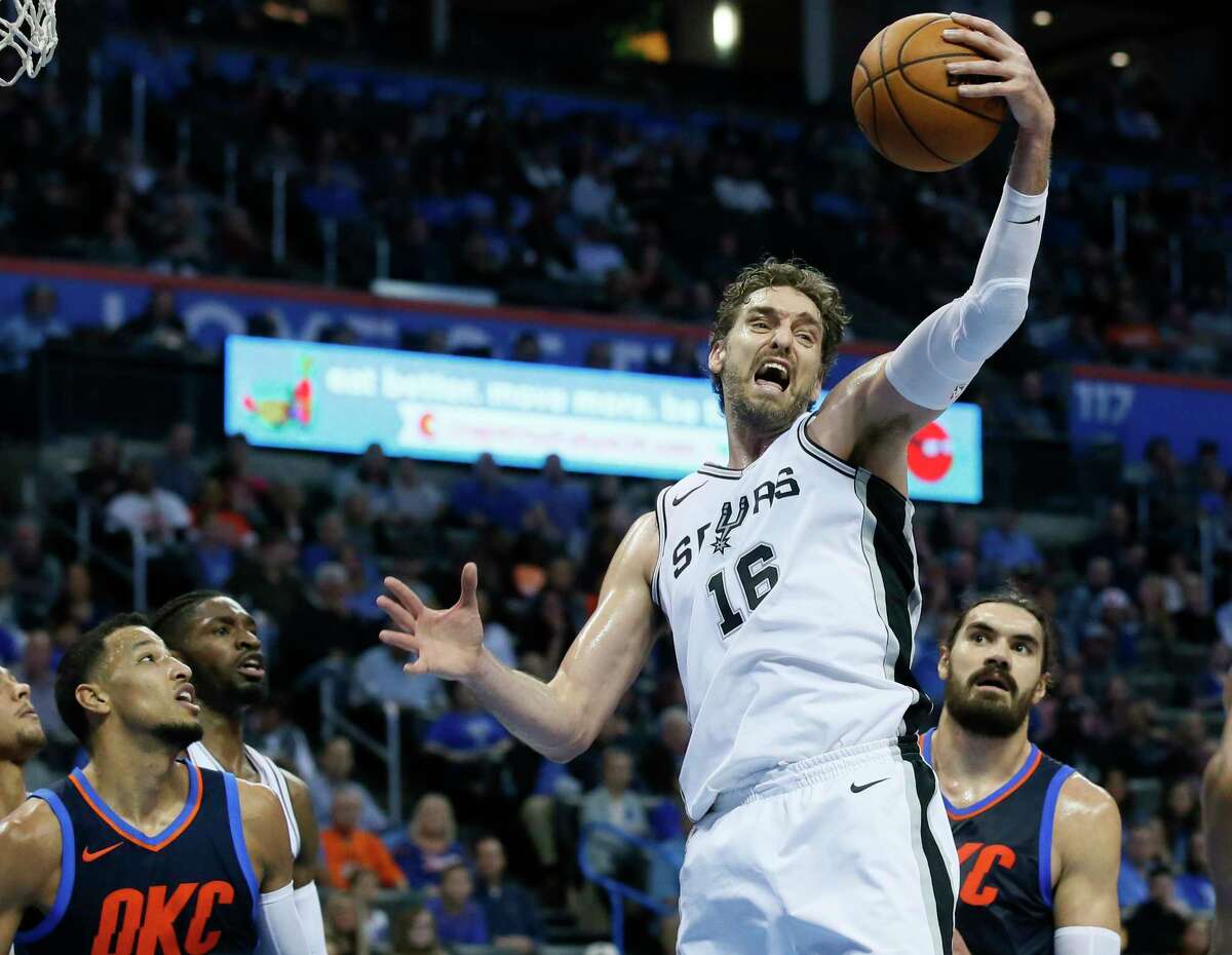 San Antonio Spurs center Pau Gasol (16) grabs a rebound between Oklahoma City Thunder guard Andre Roberson, left, and center Steven Adams, right, in the second quarter of an NBA basketball game in Oklahoma City, Sunday, Dec. 3, 2017. (AP Photo/Sue Ogrocki)
