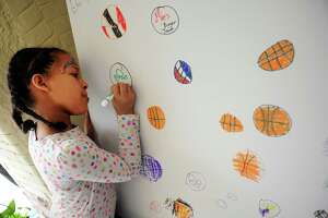 Tatyana Gloria Reyes, 8, of Bridgeport, draws while at the Arcade Mall’s Fan Fest which was held to welcome visitors attending the NCAA Basketball Championship at the Arena at Harbor Yard in downtown Bridgeport, Conn., on Saturday March 26, 2016. Activities included music by DJ Bongo Joe and his live band Off the Hook, face painting, caricatures, and food was provided from several downtown restaurants.