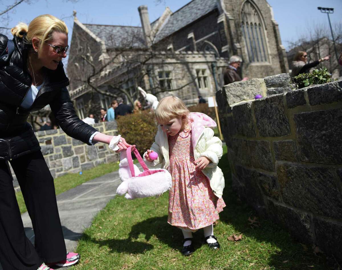 Alexandra Setterberg, 2, of Greenwich, collects eggs during the Easter egg hunt in the memorial garden at Christ Church in Greenwich, Conn. Sunday, March 27, 2016. Before the egg hunt, hundreds attended Easter mass to celebrate the resurrection of Jesus Christ and the gifts of life and love that are believed to be given through the resurrection.