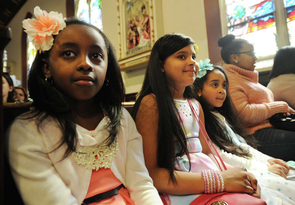 From left; Yulisa Romero, 9, Taishaly Casillas, 9, and Edelys Jorge, 6, all of Bridgeport, wear their Easter dresses and flowers in their hair to Easter services at St. Charles Borromeo Catholic Church on East Main Street in Bridgeport, Conn. on Sunday, March 27, 2016.