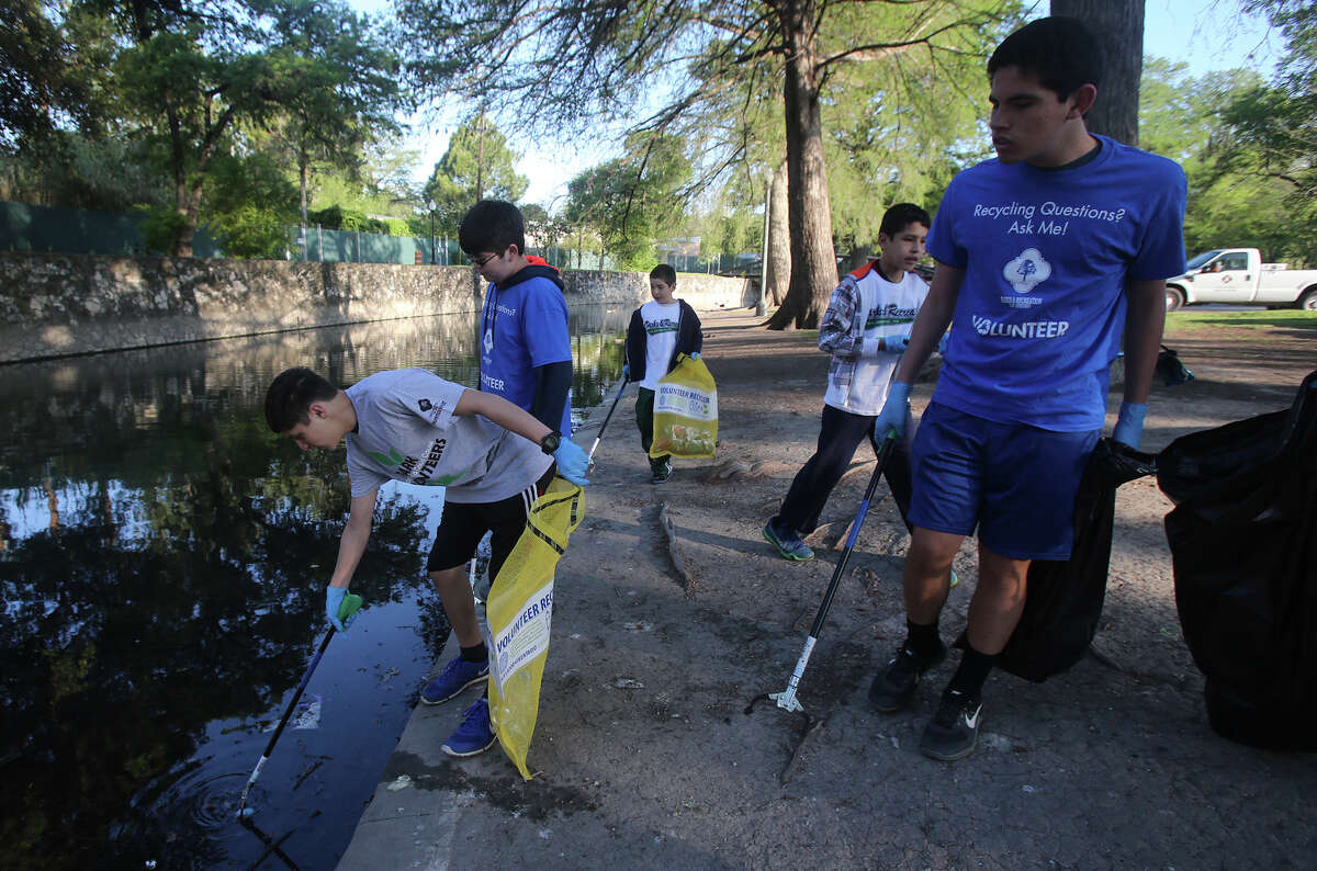 Volunteer Adrian Cano (left) picks up trash Monday March 28, 2016 at Brackenridge Park after the long Easter weekend. The city allows camping at Brackenridge and other area parks Easter weekend resulting in a high accumulation of trash. Cano was picking up trash with volunteers from Central Catholic High School.
