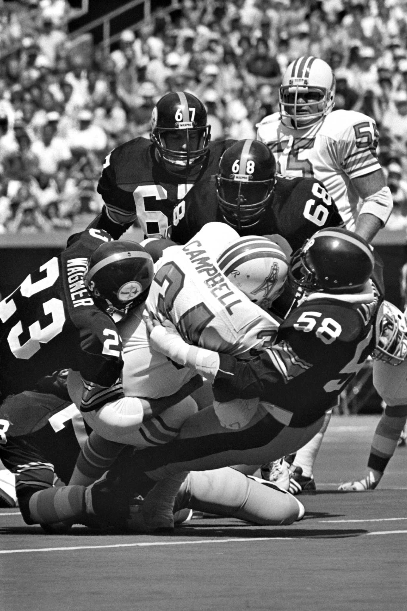 Houston Oilers Earl Campbell (34) looks for running room after