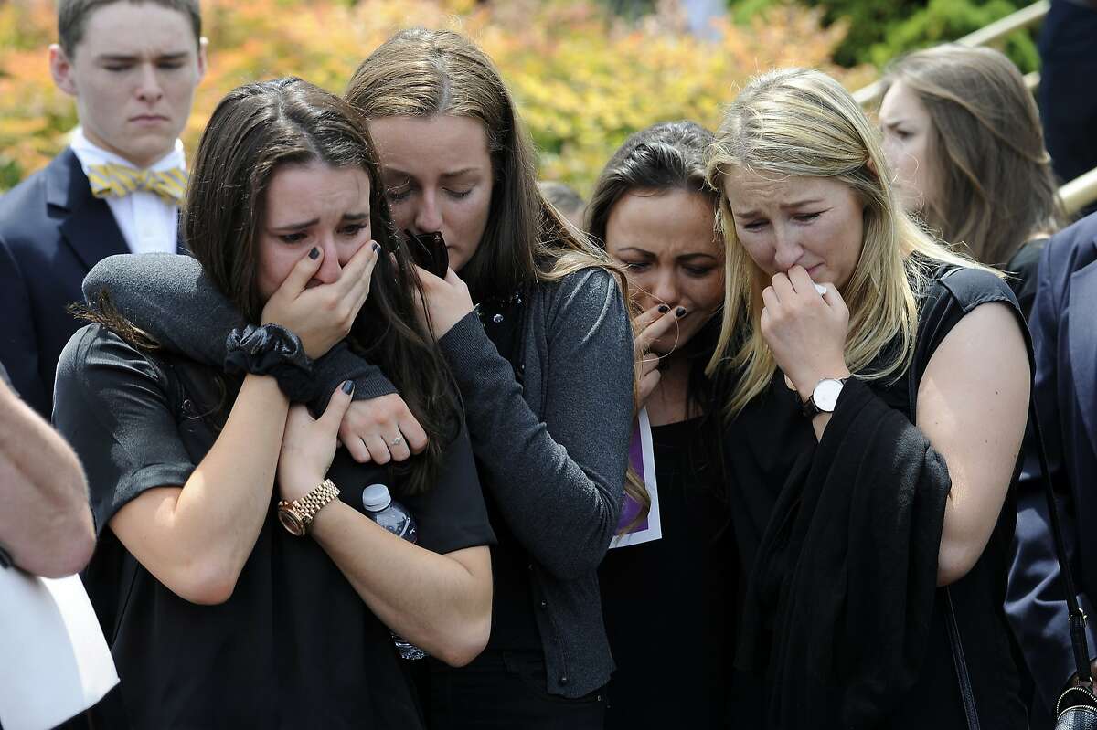 FILE- In this Saturday, June 20, 2015 file photo, mourners cry as the caskets of cousins Olivia Burke, 21, and Ashley Donohoe, 22, are placed in hearses following services at St. Joseph Catholic Church in Cotati, Calif., Saturday, June 20, 2015. The two woman were among the several people killed when a balcony snapped off the fifth floor of a Berkeley apartment building during a birthday party. The seven Irish students who survived a balcony collapse remain hospitalized in varying states of recovery nearly a week later. (AP Photo/Michael Short, File)