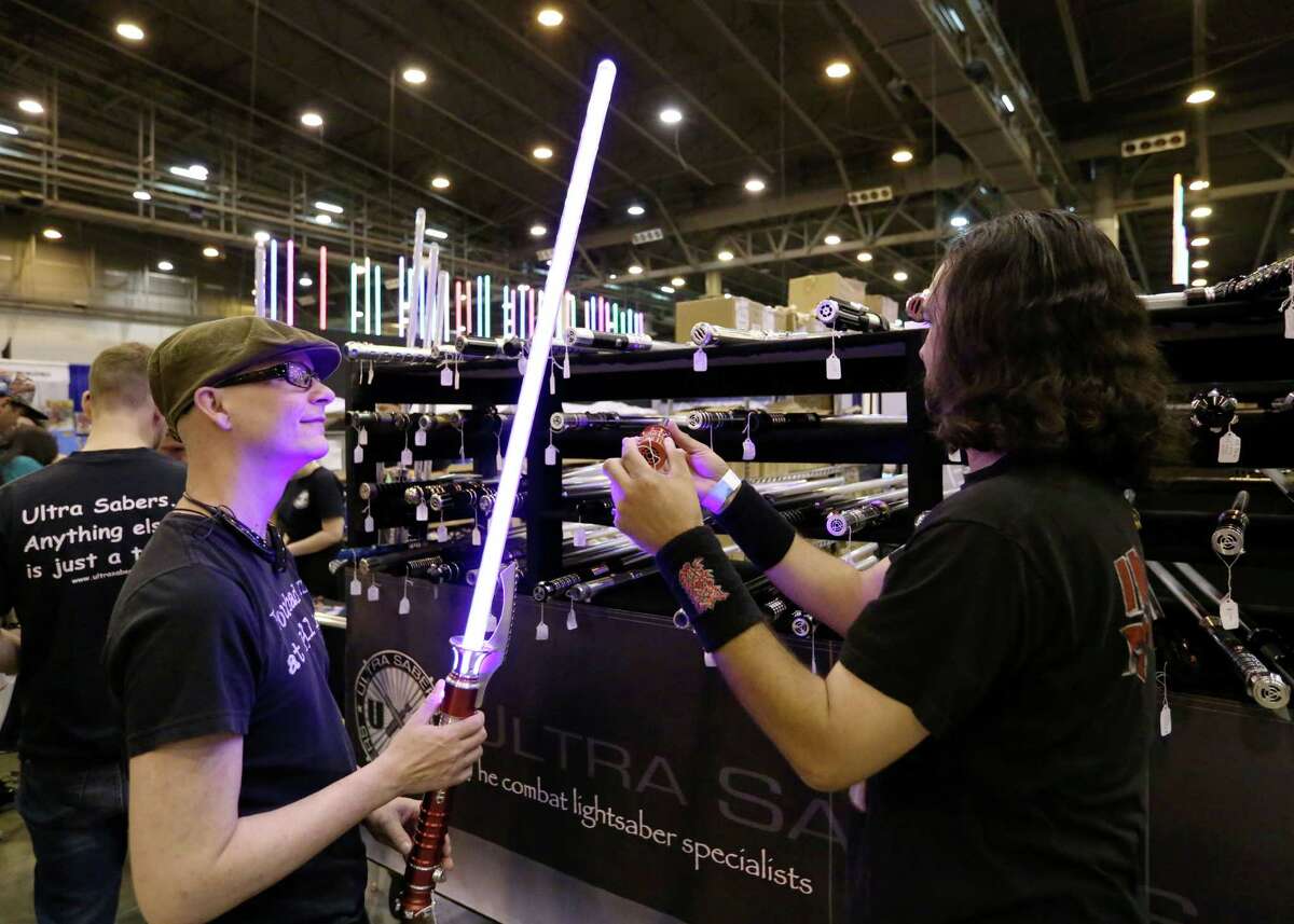 Ron Loupe, left, checks out a light saber with his friend Freddy Flores at the 2015 Space City Comic Con at NRG Center Friday, July 24, 2015, in Houston. "I just like cool light-up stuff," Loupe said. ( Jon Shapley / Houston Chronicle )