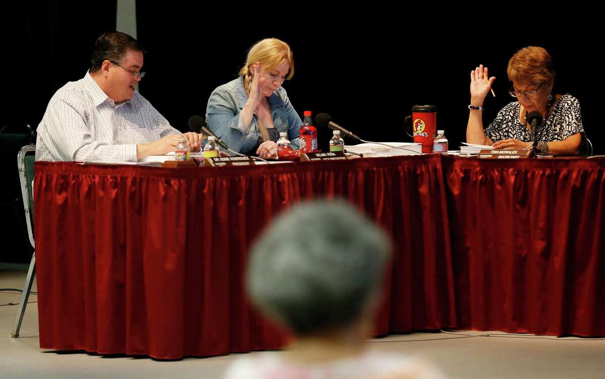 Edgewood ISD school board president Eddie Rodriguez (from left), Vice-president Velma Pena and Secretary Tina Morales vote on a proposal to go into executive session during a recent meeting held at Edgewood Fine Arts Academy on Tuesday, Sept. 8, 2015. (Kin Man Hui/San Antonio Express-News)
