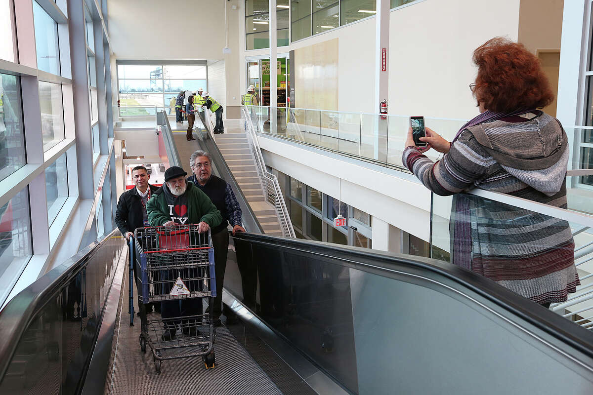 Bill Hamner, 87, is help up the Ã©¢??travelators,Ã©¢?? by Store Director Alex Toscano, left, Raymond Garcia, at the H-E-B Nogalitos, Tuesday, Jan. 13, 2015. The store is undergoing a reconstruction and is scheduled to open on Friday. Most of the building was demolished and the company kept the facade. The size of the old store was 26,000 square feet and the new store's footprint is 62,000 square feet. The travelators will be used to move shoppers to the second floor store. Extra wide elevators are also used at the store.