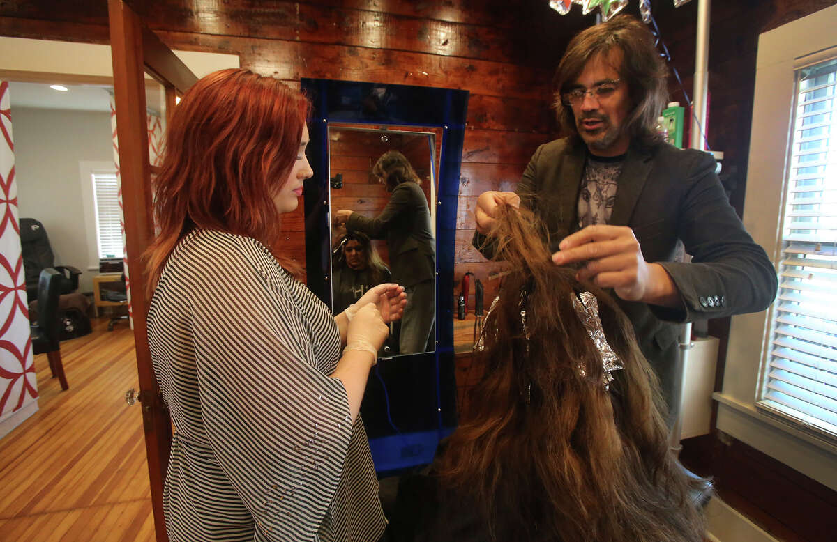 Andrew Guerra (right), owner of the Ritz Hair Hair Studio, styles Marlen Montes' hair Friday March 25, 2016. The salon is a subject of controversy in the Mahncke Park neighborhood just north of downtown after Guerra spent thousands of dollars renovating the structure for his business. The property is zoned residential and neighborhood residents are fighting a zoning change, saying the business hurts the fabric of the neighborhood. Helping (left) is Codi Everett.