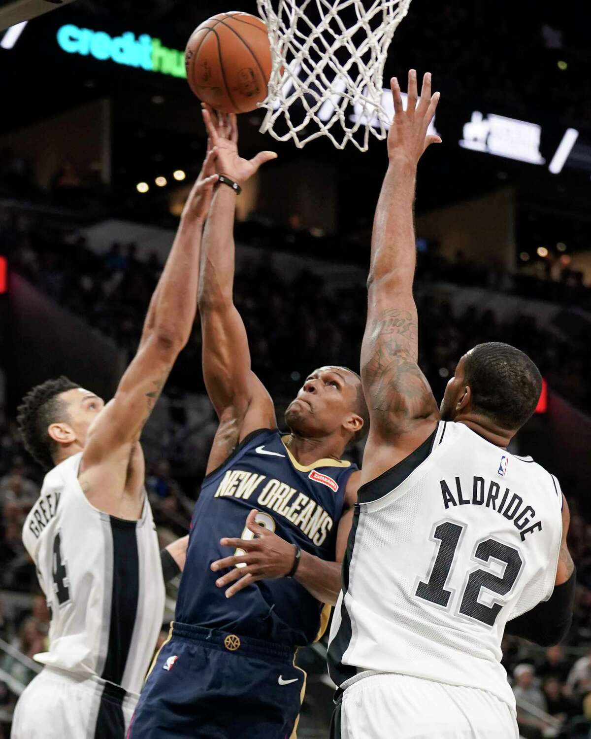 New Orleans Pelicans' Rajon Rondo, center, shoots against San Antonio Spurs' LaMarcus Aldridge (12) and Danny Green during the first half of an NBA basketball game, Thursday, March 15, 2018, in San Antonio. (AP Photo/Darren Abate)