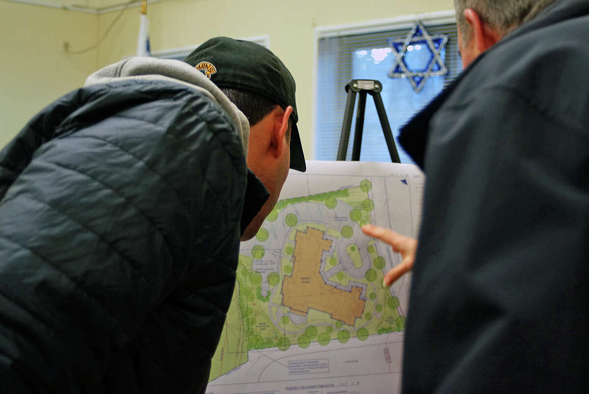 Neighbors check out the site plan for a proposed assisted living facility for property on Stratfield Road, now home to a synagogue.