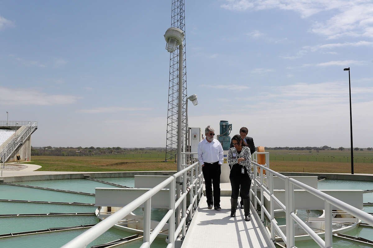 Bill Mullican, from left, formerly a member of the Texas Water Development Board, talks with Richard Donat, a planner with SAWS desalination project, and Hope Wells, SAWS corporate counsel, as they walk on a clarifier during a tour of SAWS Twin Oaks Aquifer Storage and Recovery Facility in South Bexar County in 2014.