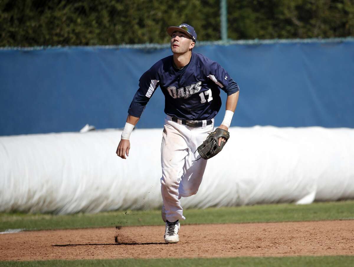 Lucas Erceg (17) runs in for a pop fly from his position at third base during Menlo College's game against Lewis-Clark State College in Atherton, California, on Wednesday, March 30, 2016.