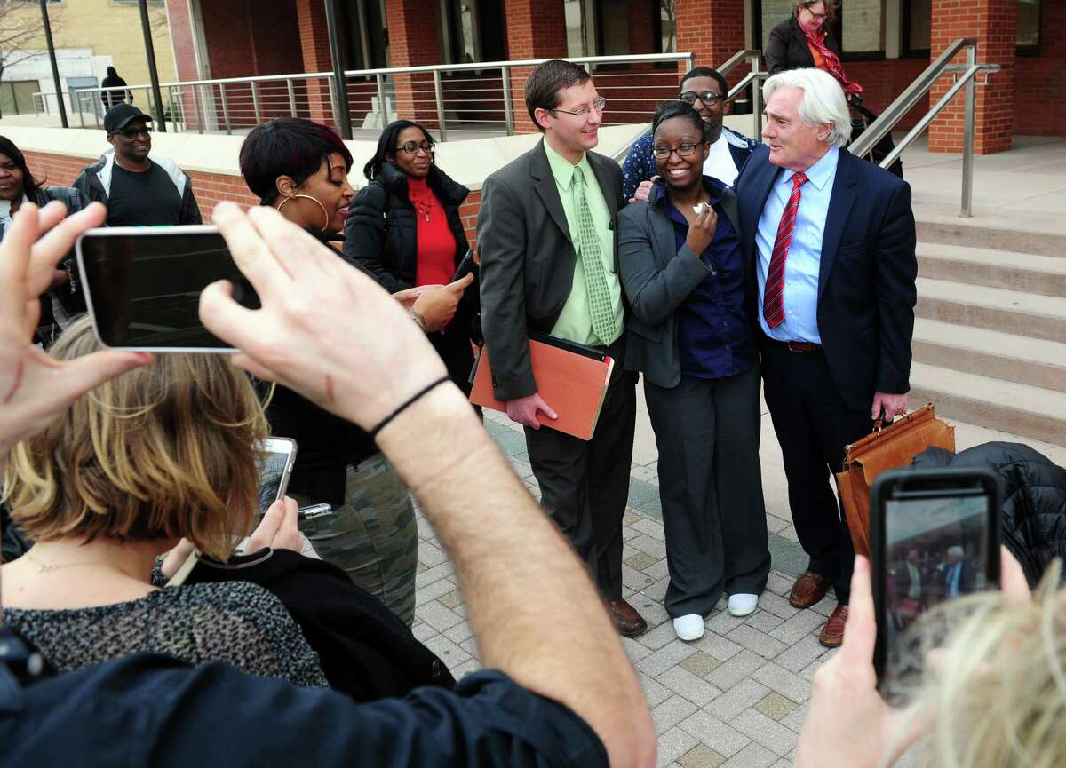 Cherelle Baldwin, a young mother who claims she crushed her abusive boyfriend Jeffrey Brown with her car in self-defense, poses with her attorneys Matthew Popilowski and Miles Gerety, at right, after being found not guilty at Superior Court on Main Street in Bridgeport, Conn., on Thursday Mar. 31, 2016.