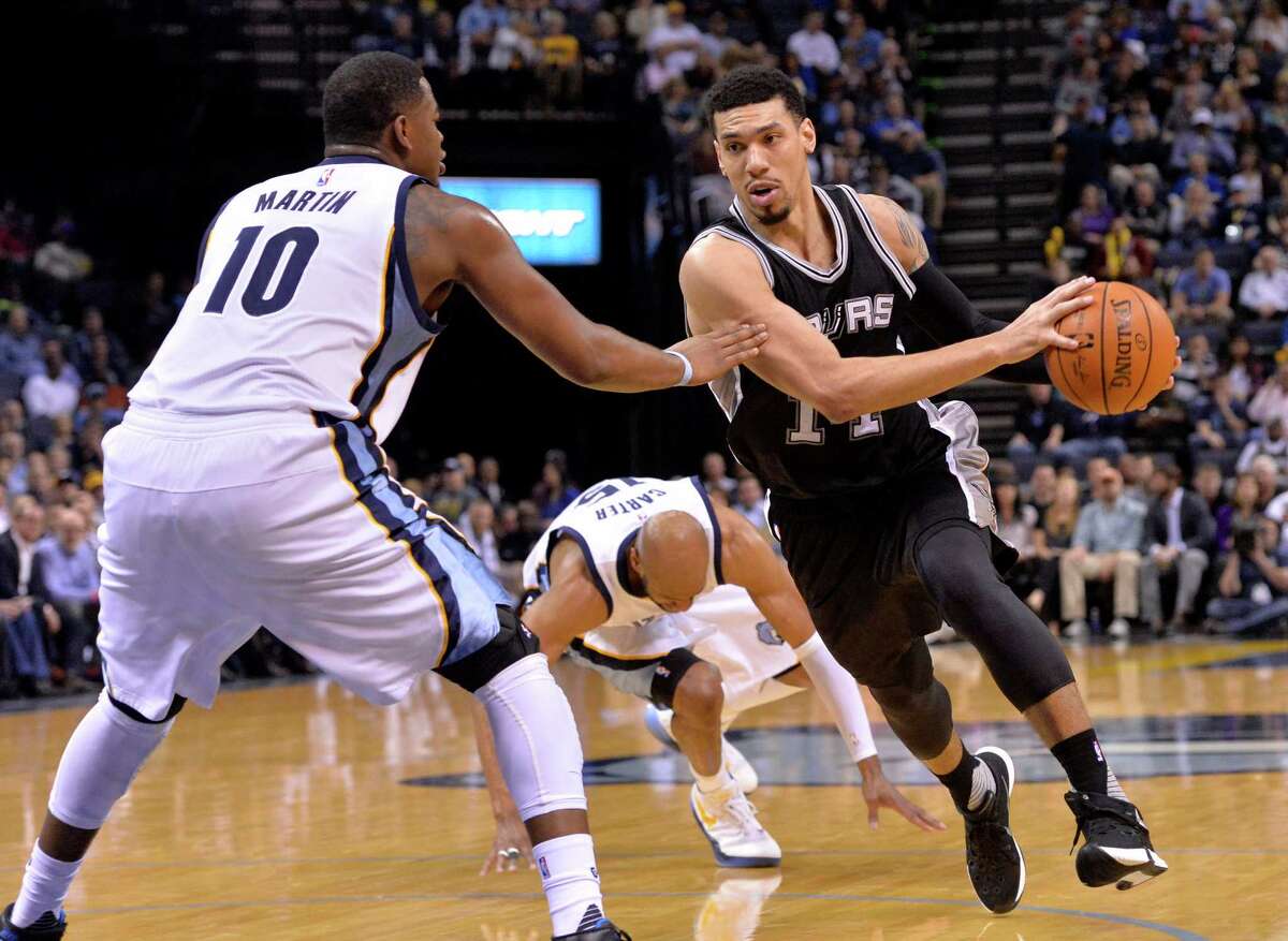 Spurs guard Danny Green drives against Grizzlies forward Jarell Martin (10) as Grizzlies guard Vince Carter (center) falls to the court in the second half on March 28, 2016, in Memphis, Tenn.