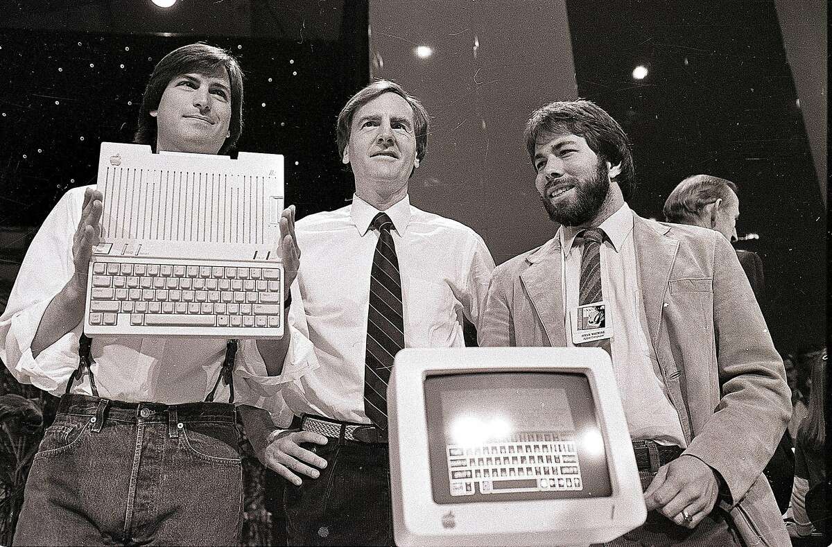 Steve Jobs, left, chairman of Apple Computers, John Sculley, center, then president and CEO, and Steve Wozniak, co-founder of Apple, unveil the new Apple IIc computer in San Francisco in 1984.