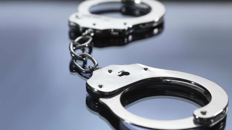 File photo of handcuffs on table. Close up of metal handcuffs