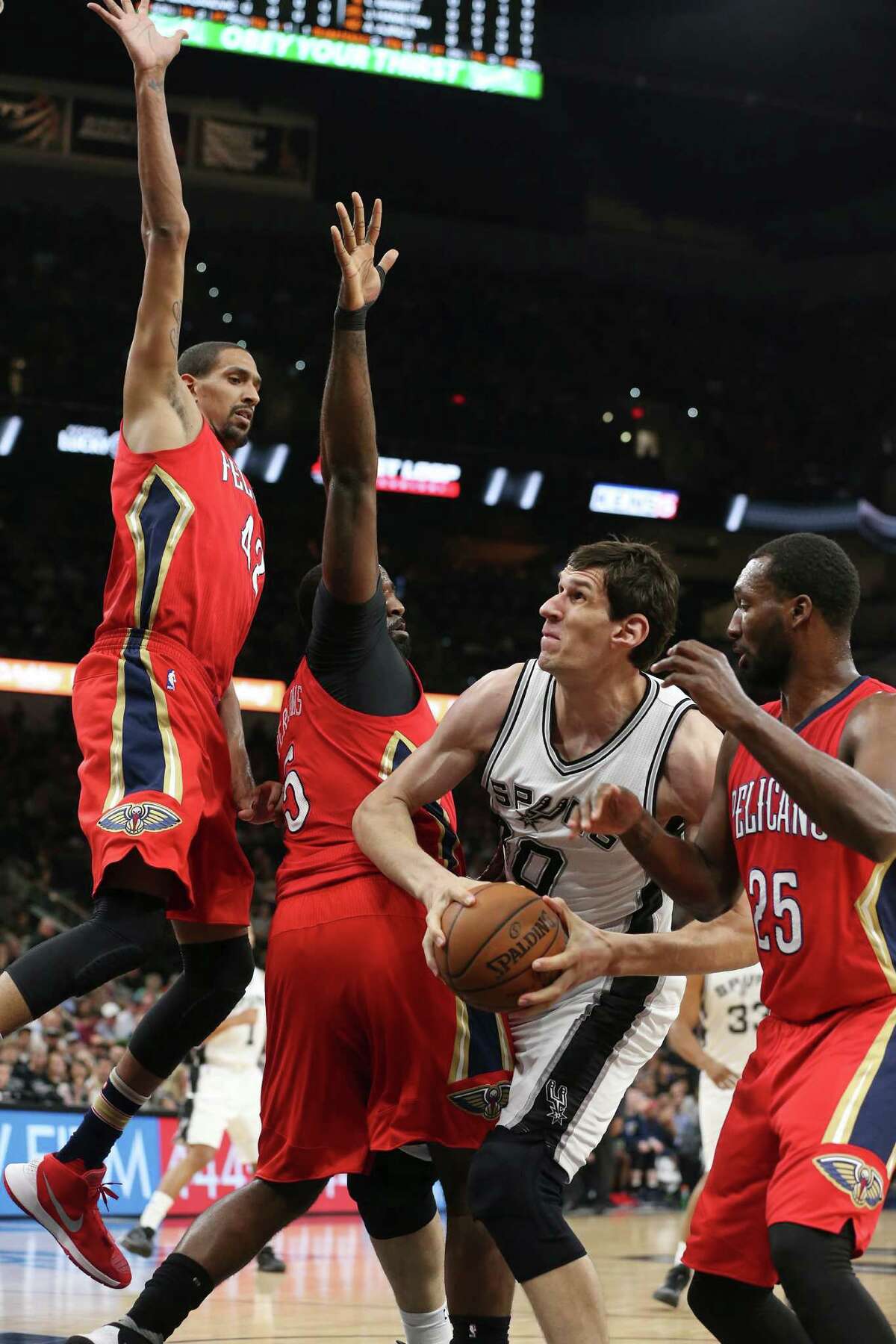 San Antonio Spurs' Boban Marjanovic looks to get through New Orleans Pelicans' Alexis Ajinca, from left, Kendrick Perkins and Jordan Hamilton during the first half at the AT&T Center, Wednesday, March 30, 2016.
