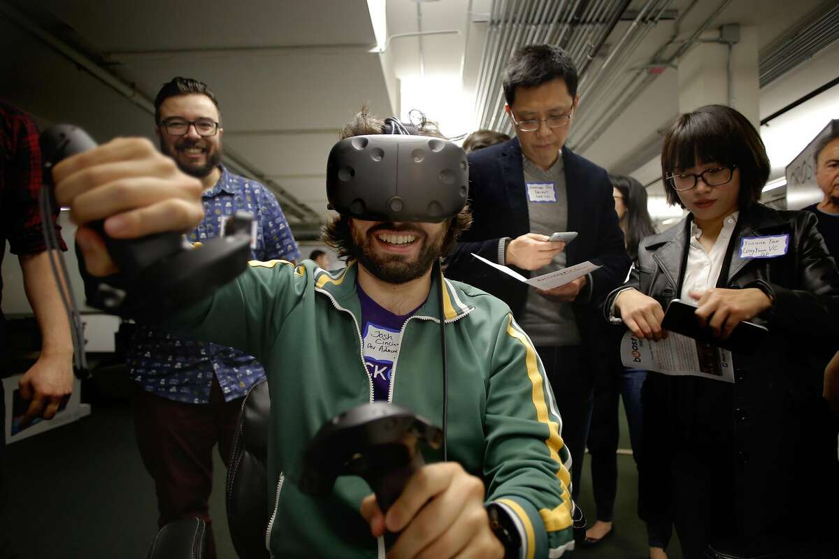 Josh Cincinnati with the company Blockcypher tries out the vr racing game monowheels by the company Imagination Studio, a game development studio and great VR content, during the BOOST VC, the premier seed-stage accelerator for virtual reality and blockchain companies to share their visions and products, in San Mateo, California, on Thurs. March 31, 2016