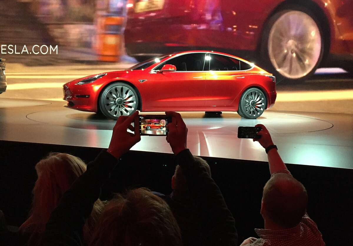 Tesla Motors unveils the new lower-priced Model 3 sedan at the Tesla Motors design studio in Hawthorne, Calif., Thursday, March 31, 2016. It doesn't go on sale until late 2017, but in the first 24 hours that order banks were open, Tesla said it had more than 115,000 reservations. Long lines at Tesla stores, reminiscent of the crowds at Apple stores for early models of the iPhone, were reported from Hong Kong to Austin, Texas, to Washington, D.C. Buyers put down a $1,000 deposit to reserve the car. (AP Photo/Justin Prichard)