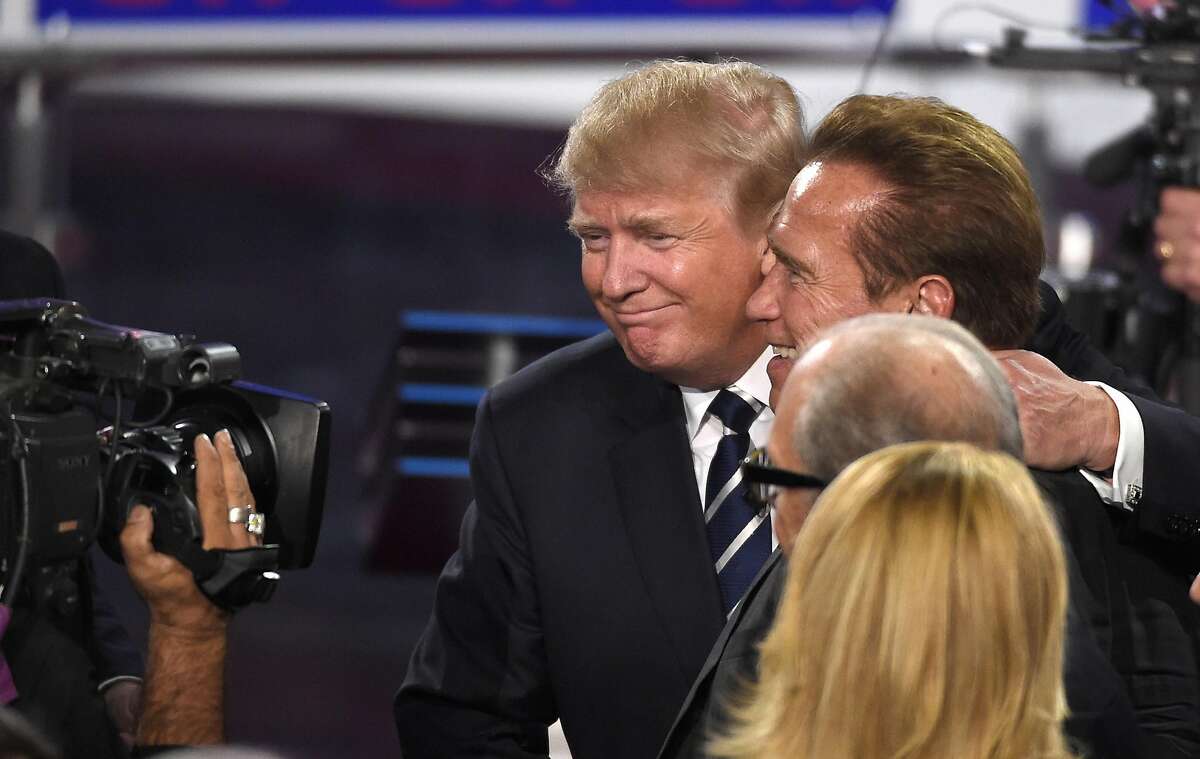 Republican presidential candidate, businessman Donald Trump, center, hugs former California Gov. Arnold Schwarzenegger following the CNN Republican presidential debate at the Ronald Reagan Presidential Library and Museum on Wednesday, Sept. 16, 2015, in Simi Valley, Calif. (AP Photo/Mark J. Terrill)