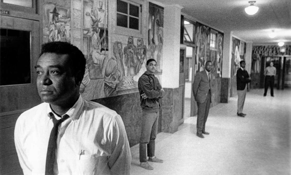 John Biggers, head of the art department at Texas Southern University, with students and murals at Texas Southern University in 1965. TSU president Samuel Nabrit let Biggers and his students fill the university's hallways with public art.