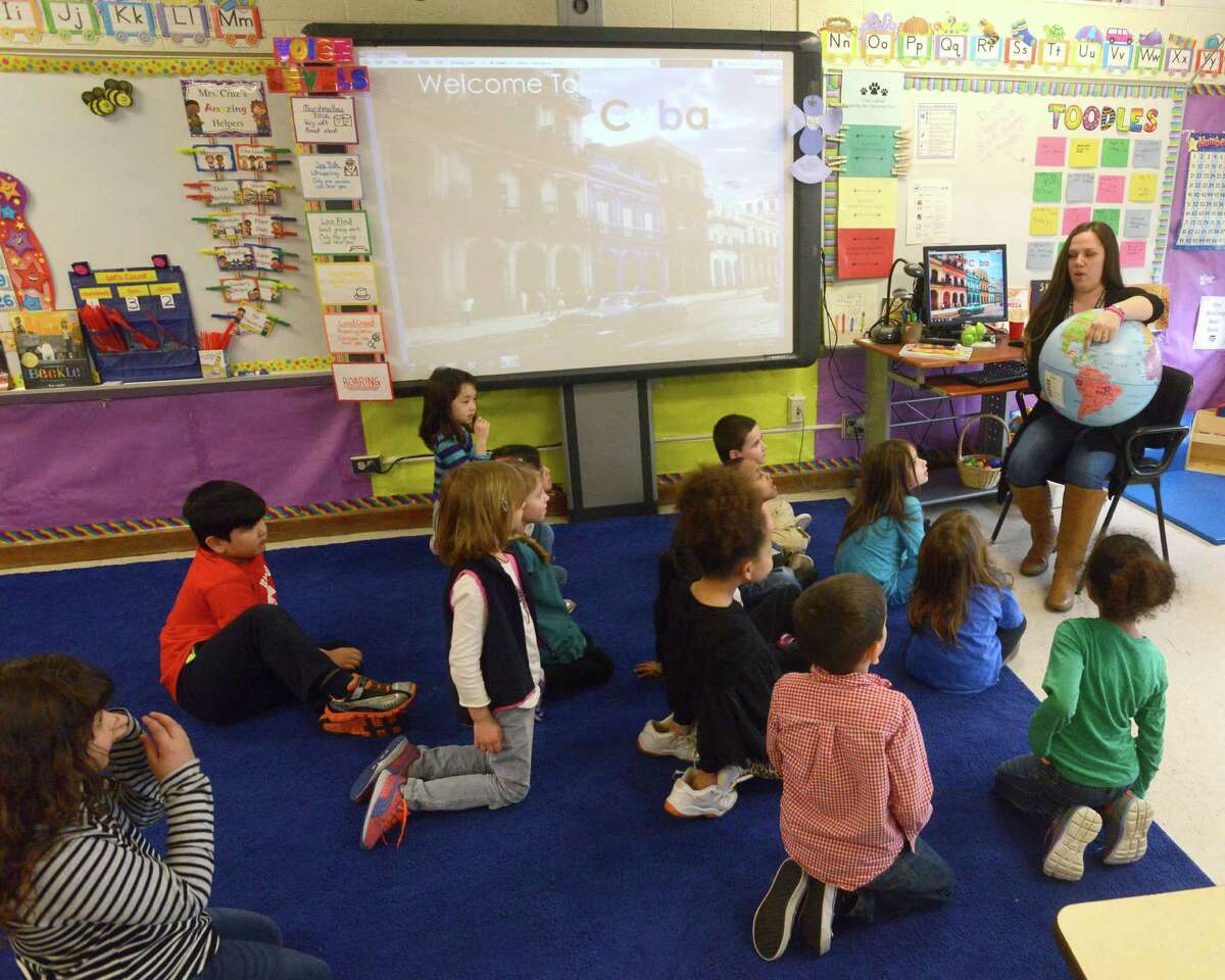 Laura Cruz, a kindergarten teacher at Springdale School in Stamford, points out the country of Cuba to her students on April 1, 2016. Cruz was celebrating the Cuban heritage of one of her students, Violet Mohr, who's grandmother immigrated from Cuba in 1961.
