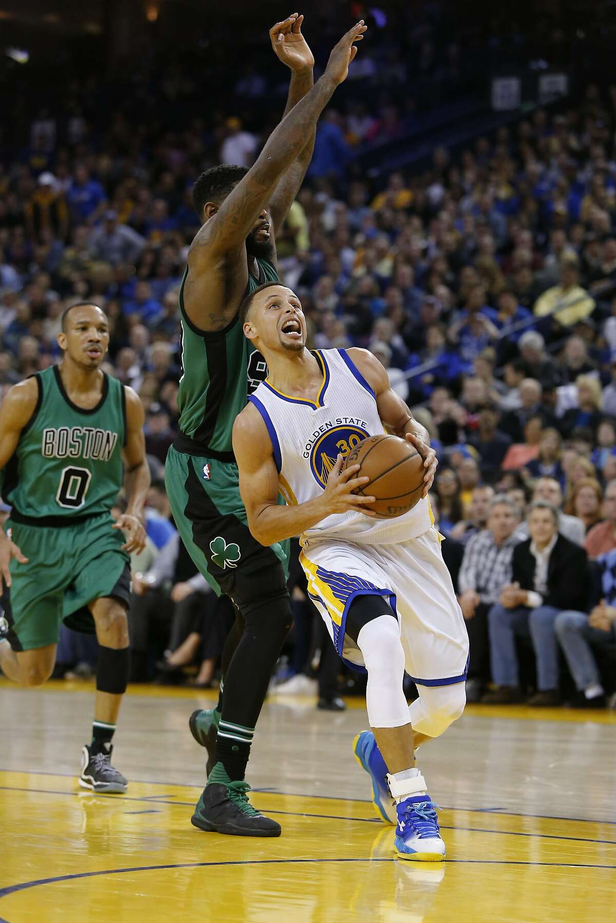 Warriors' Stephen Curry, 30 drives past the Celtics' Amir Johnson, 90 in the second half, as the Golden State Warriors went on to lose to the Boston Celtics 106-109 in NBA action at Oracle Arena, in Oakland, California, on Fri. April 1, 2016